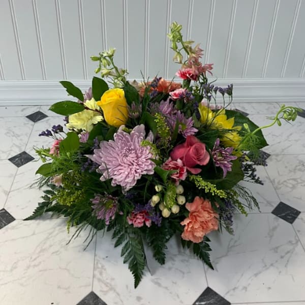 Low mixed bouquet with roses, chrysanthemums, and carnations in pink, yellow, and lavender