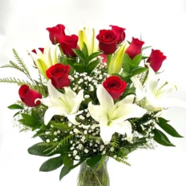 Red roses and white lilies in a clear glass vase