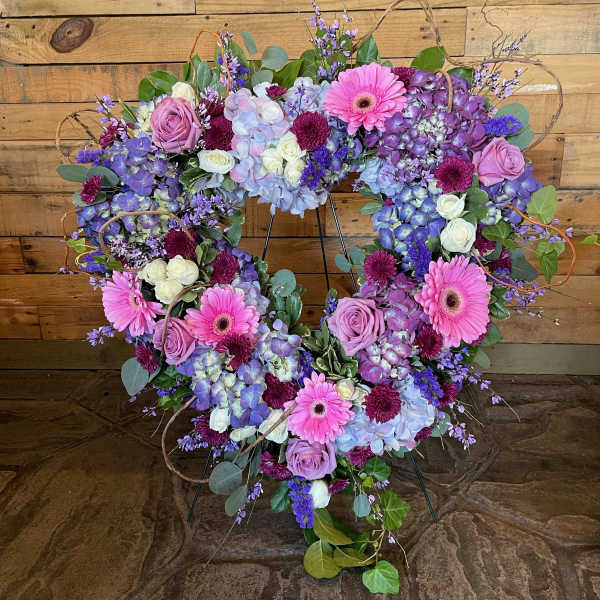 Heart-shaped floral wreath with pink, purple, and white blooms