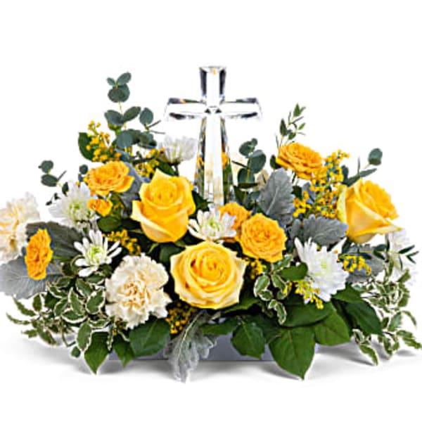 Yellow and white floral arrangement with a clear glass cross centerpiece