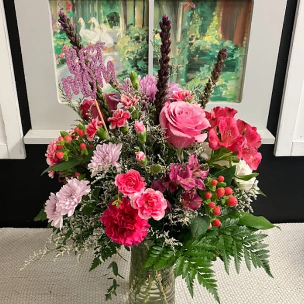 Pink and red mixed flower arrangement in a glass vase