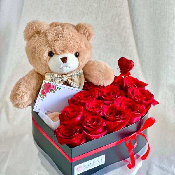 Teddy bear with red roses in a black gift box