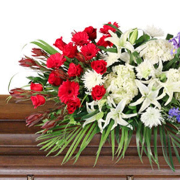 Red, white, and purple floral spray on a casket