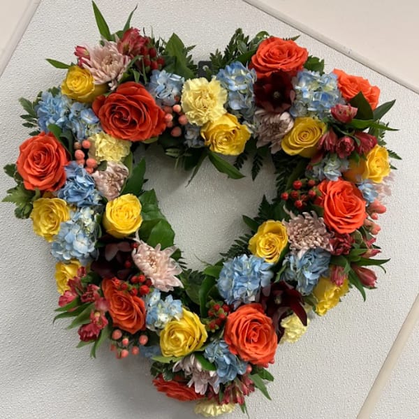 Heart-shaped floral wreath with multicolored roses and hydrangeas