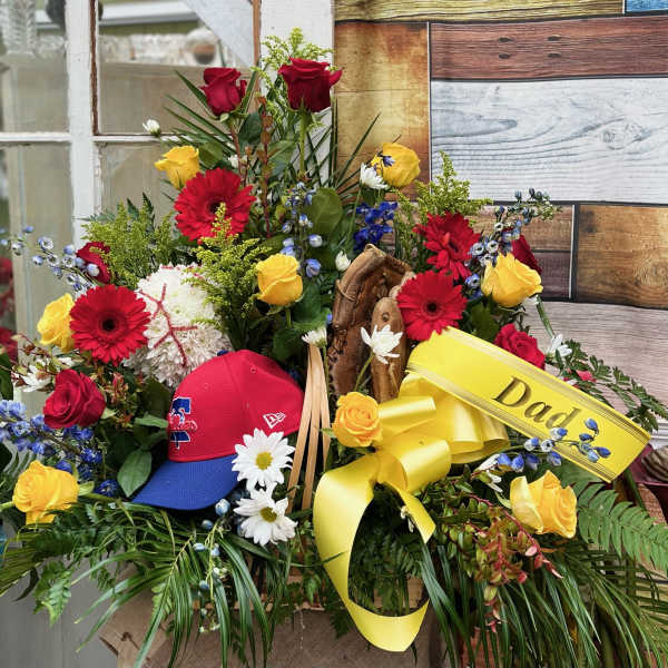 Floral arrangement with red and yellow roses, gerbera daisies, and a yellow ribbon