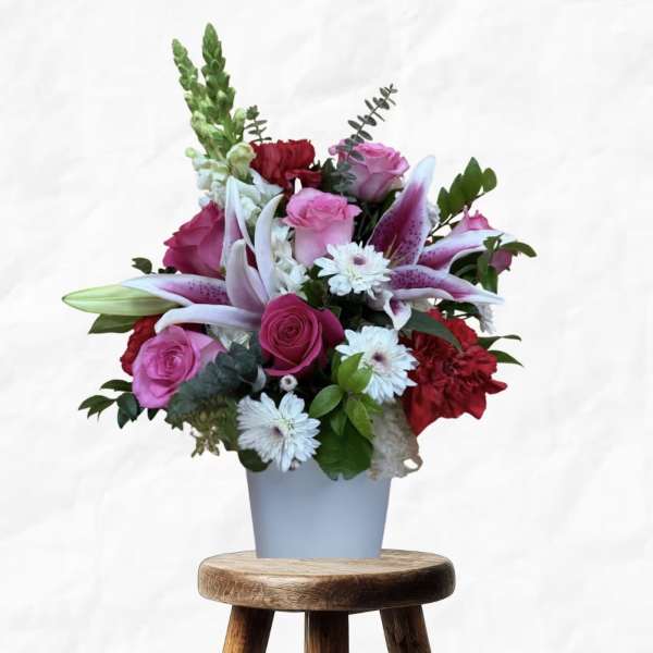 Pink roses and lilies arranged in a light blue vase