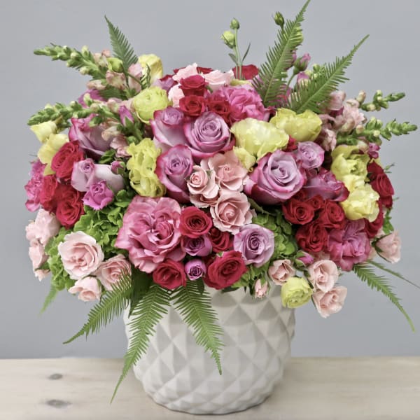 Mixed pink and red roses in a white textured vase