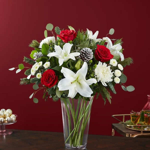 Red roses and white lilies arranged in a clear glass vase