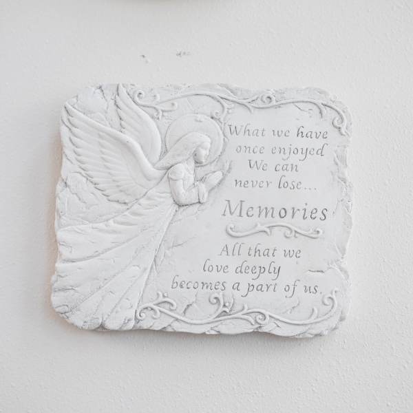 White memorial plaque with an angel and engraved quote