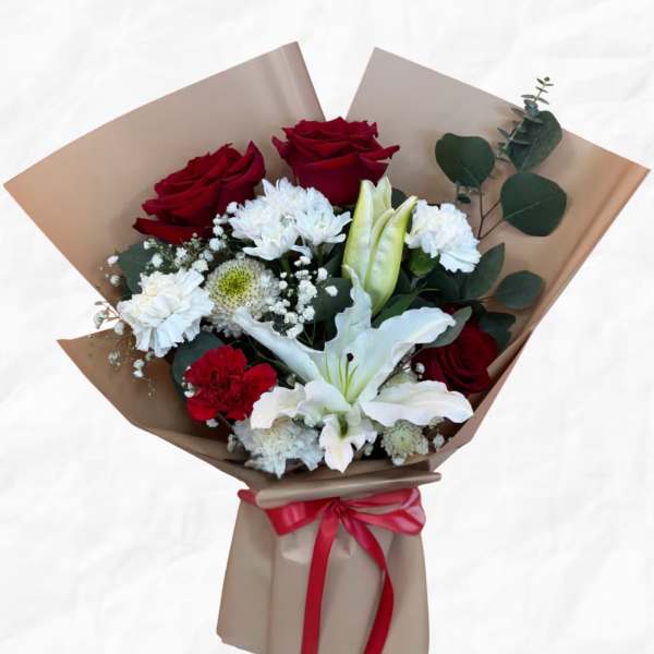Bouquet of red roses, white lilies, and white filler flowers wrapped in brown paper
