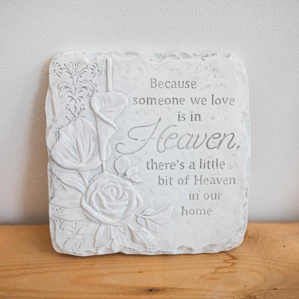 White memorial plaque with embossed flowers and a sympathy quote