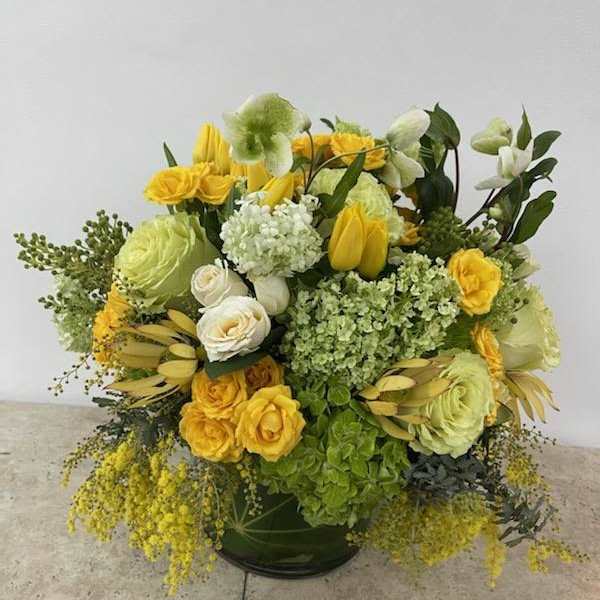 Yellow and white floral arrangement in a dark vase