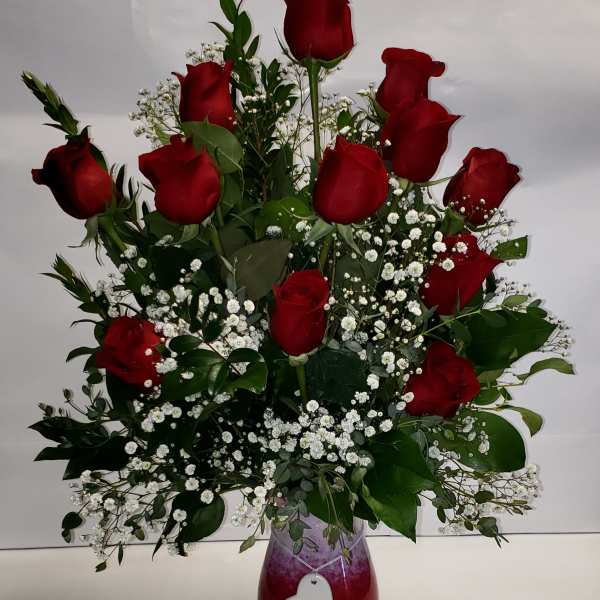 Red roses arranged in a vase with white baby's breath