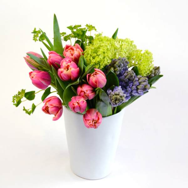 Pink tulips and green hydrangeas in a white vase
