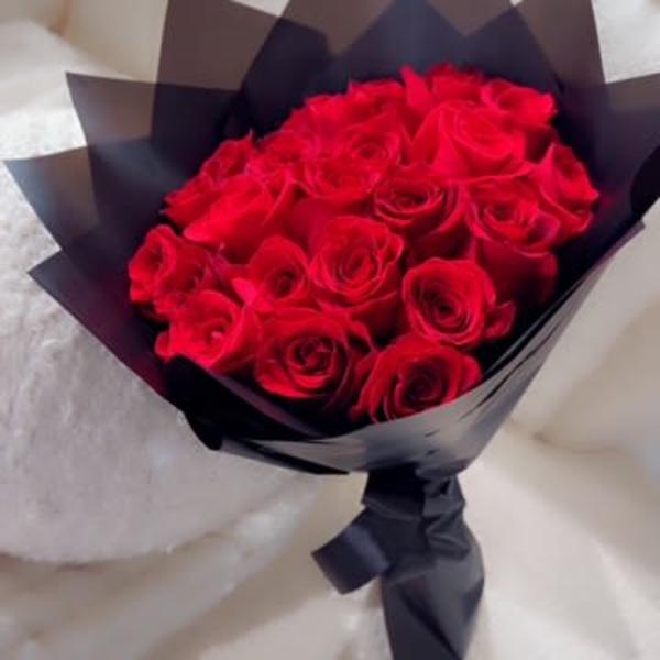 Bouquet of red roses wrapped in black paper