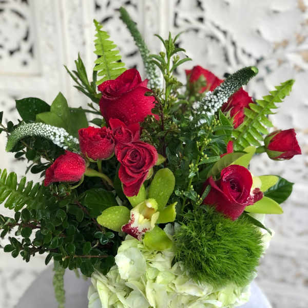Red roses and white hydrangea in a vase with green accents