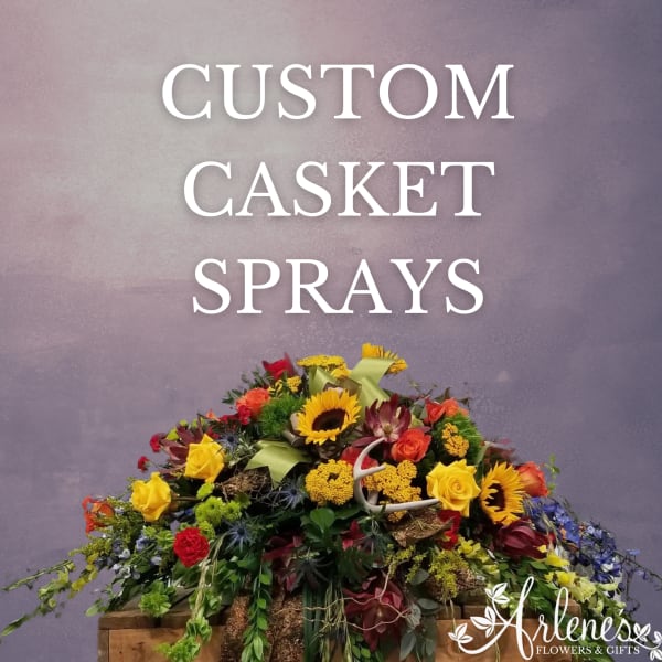 Colorful casket spray with sunflowers, roses, and mixed blooms
