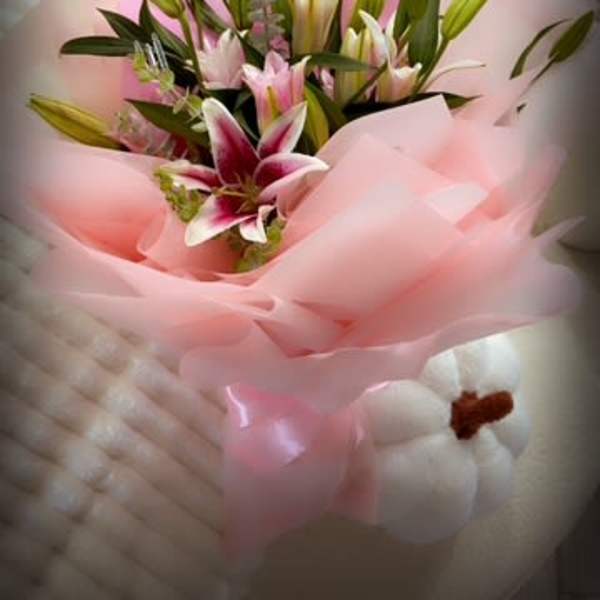 Bouquet of pink and white lilies wrapped in pink paper