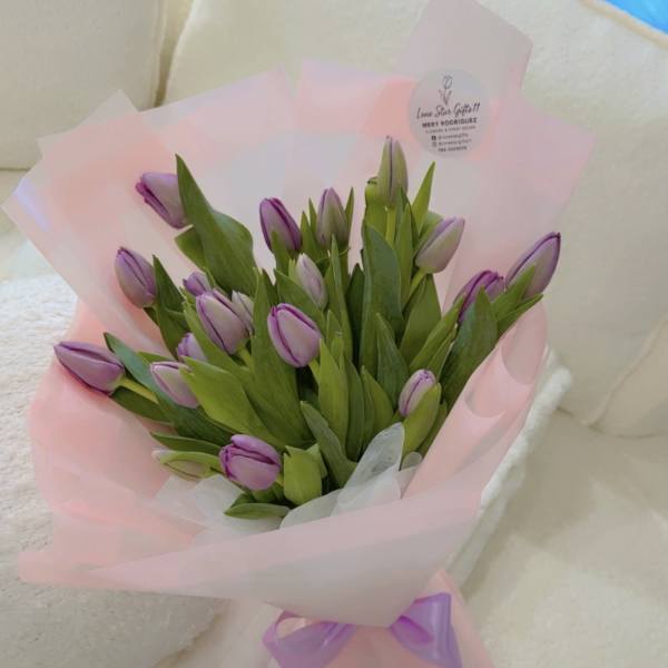 Bouquet of purple tulips wrapped in pink paper
