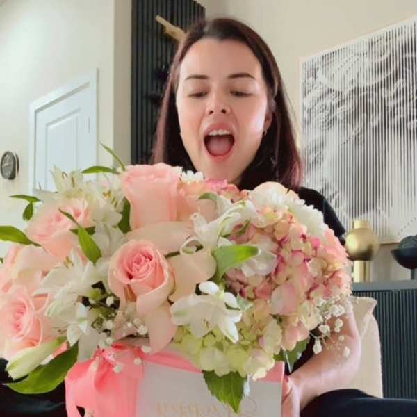 Woman holding a pastel pink flower box with roses and hydrangeas