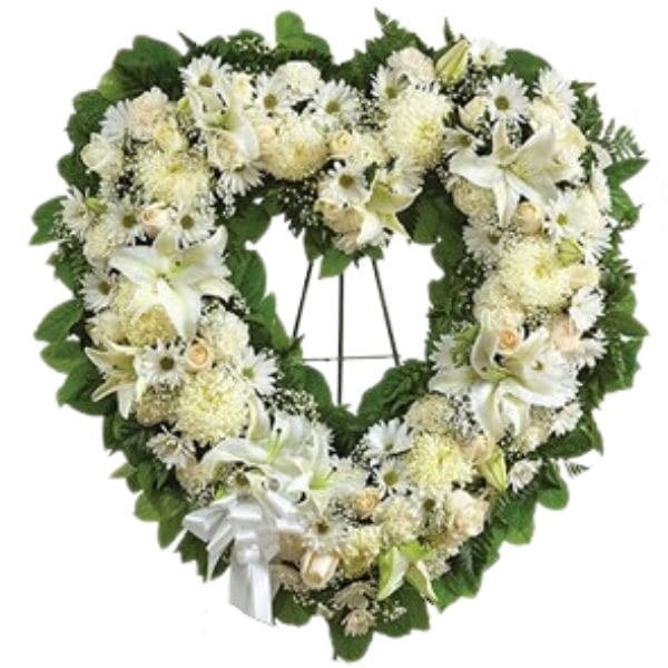 Heart-shaped white floral wreath on a stand with a white ribbon
