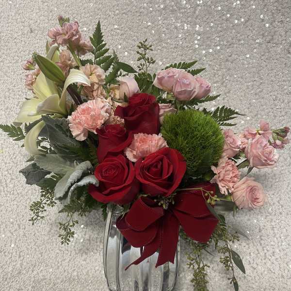 Bouquet of red and pink roses with lilies in a glass vase