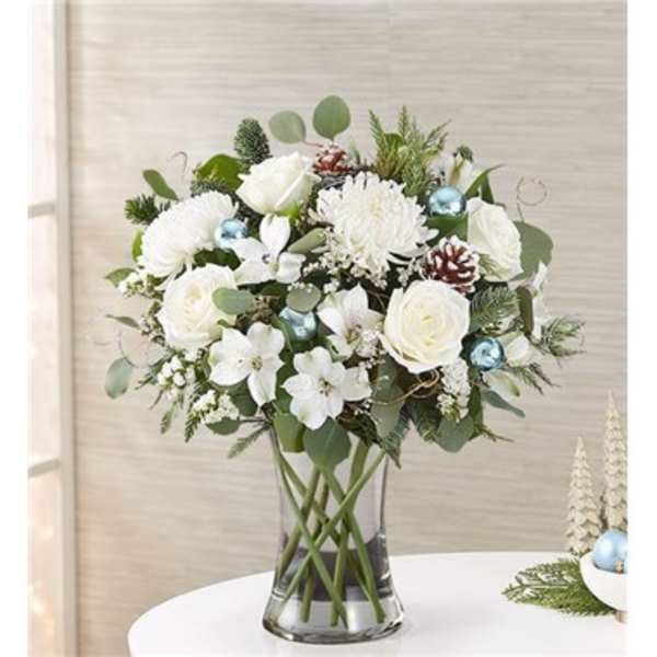 White floral arrangement in a clear glass vase with blue ornaments