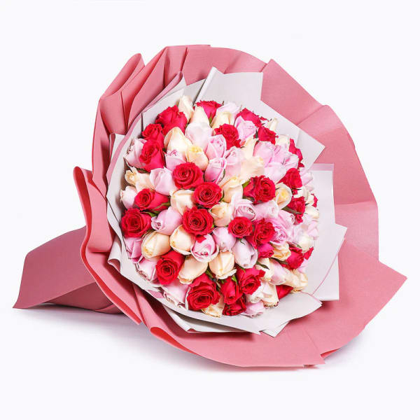 Bouquet of pink, red, and cream roses wrapped in pink paper