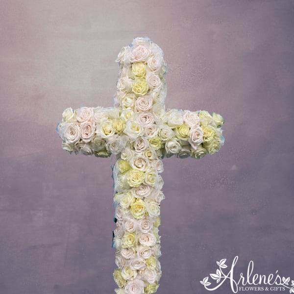 Cross-shaped floral arrangement of pale roses on a lavender background