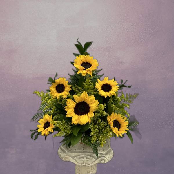 Sunflower arrangement in a decorative pedestal vase