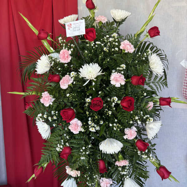 Standing floral spray with red roses, white chrysanthemums, and pink carnations