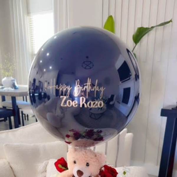 Teddy bear with red and white flowers and a birthday balloon