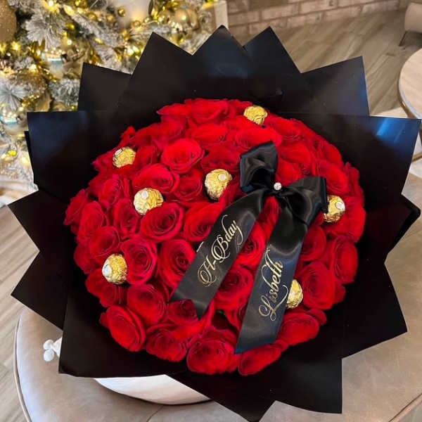 Red rose bouquet with gold-wrapped chocolates and black ribbon