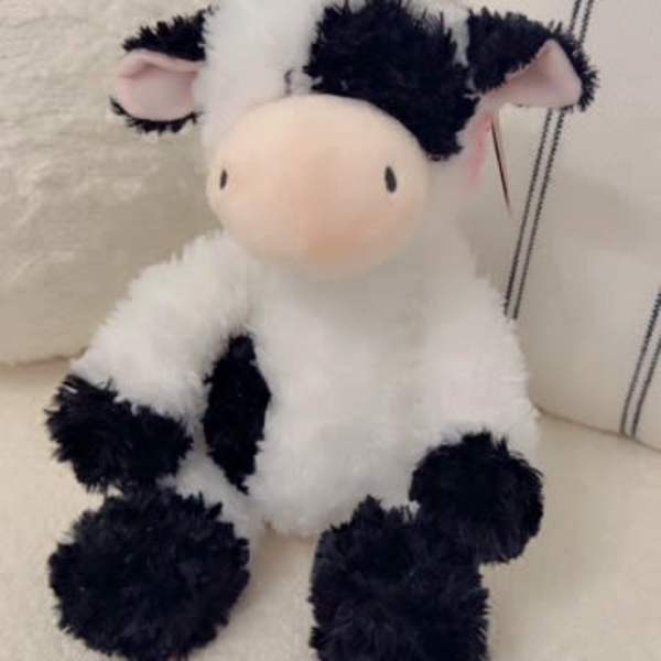 Plush cow toy sitting on a chair