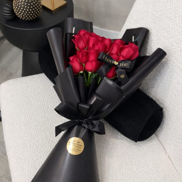Bouquet of red roses wrapped in black paper with a black ribbon