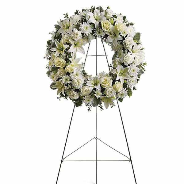 White floral wreath on a black standing easel