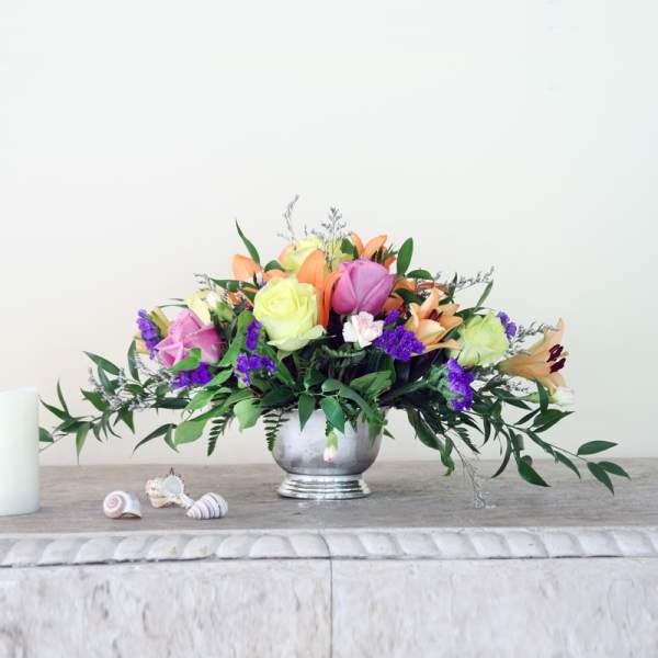 Mixed bouquet of roses and lilies in a silver vase