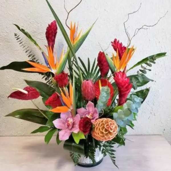Tropical flower arrangement with red and orange blooms in a vase