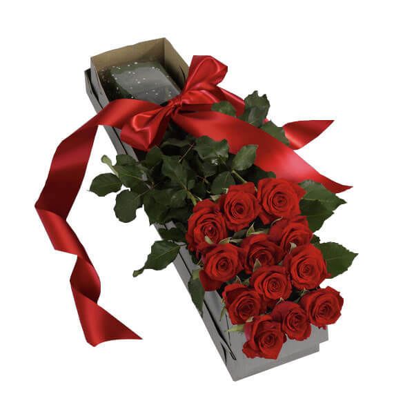 Red roses arranged in a rectangular gift box with a red ribbon
