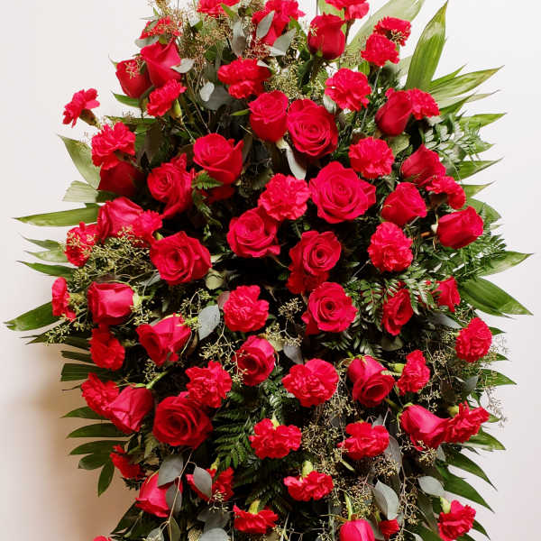 Large standing spray of red roses and carnations on an easel