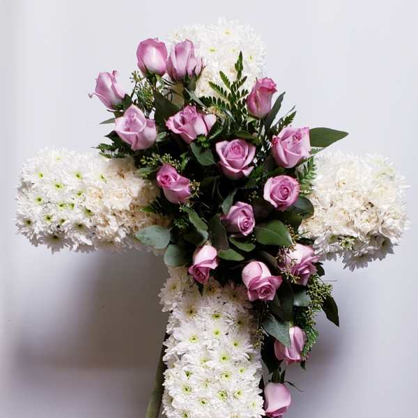 Cross-shaped floral tribute with pink roses and white chrysanthemums