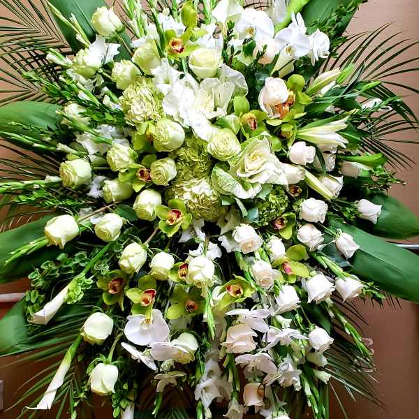 Large white and green floral standing spray with orchids and roses