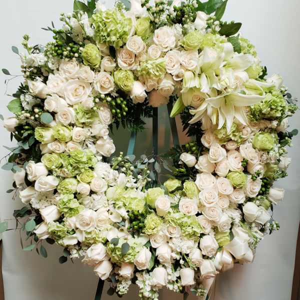 Large circular wreath of white and pale green flowers on an easel