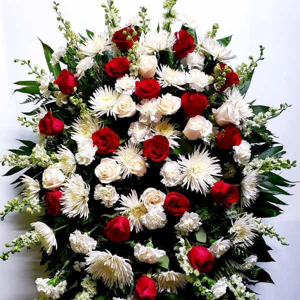 Large standing spray of red and white flowers on an easel