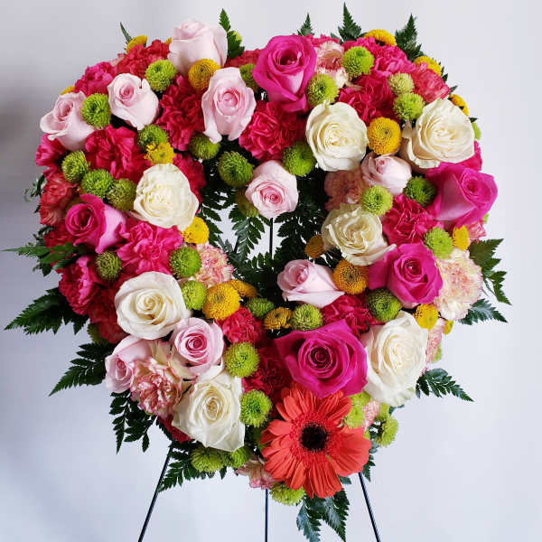 Heart-shaped floral wreath with pink and white roses and bright accent flowers