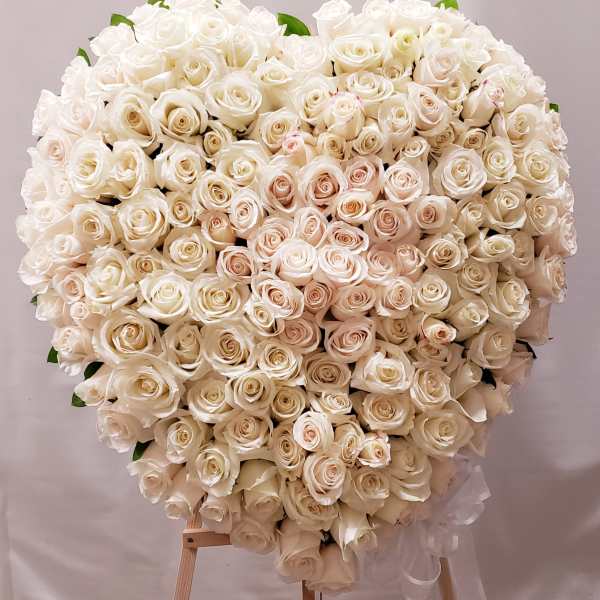 Large heart-shaped bouquet of white roses on a stand