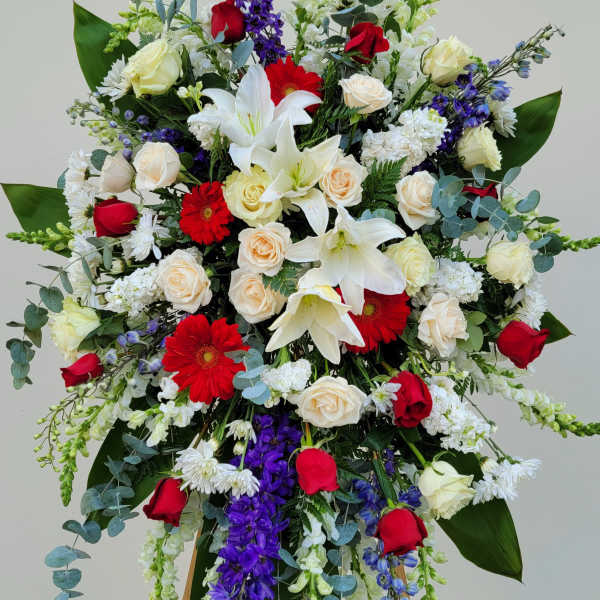 Large standing floral spray with red, white, and purple flowers on an easel