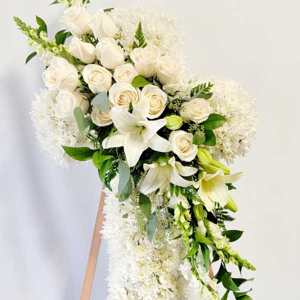 White floral standing spray with roses, lilies, and chrysanthemums on an easel