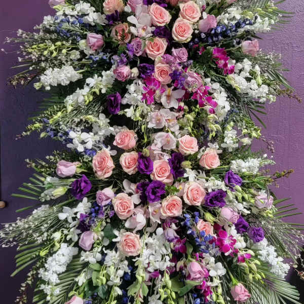 Large standing floral spray with pink and purple roses and orchids