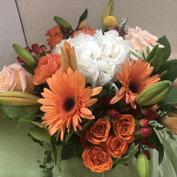 Bouquet of orange and white flowers with pale pink roses